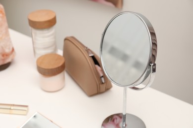 Dressing table with mirror and cosmetic products in makeup room