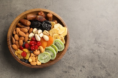 Photo of Plate with different dried fruits and nuts on table, top view. Space for text