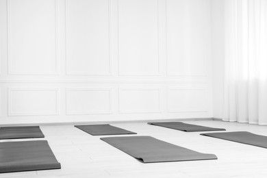 Spacious yoga studio with exercise mats. Space for text