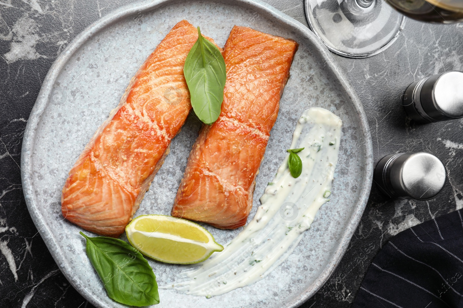 Photo of Tasty cooked red fish on dark marble table, flat lay