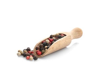 Wooden scoop with different pepper grains on white background