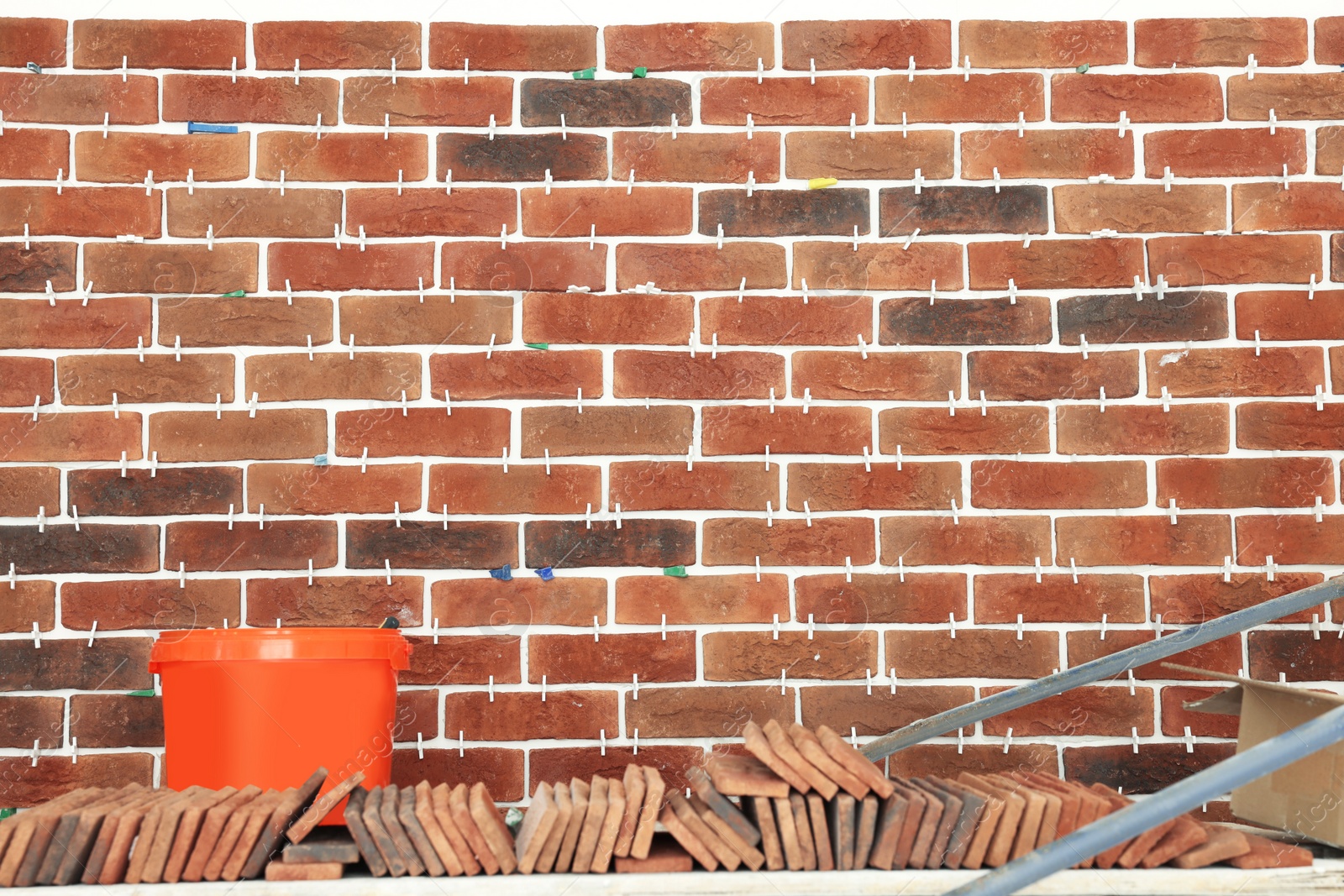 Photo of Decorative bricks with tile leveling system on wall