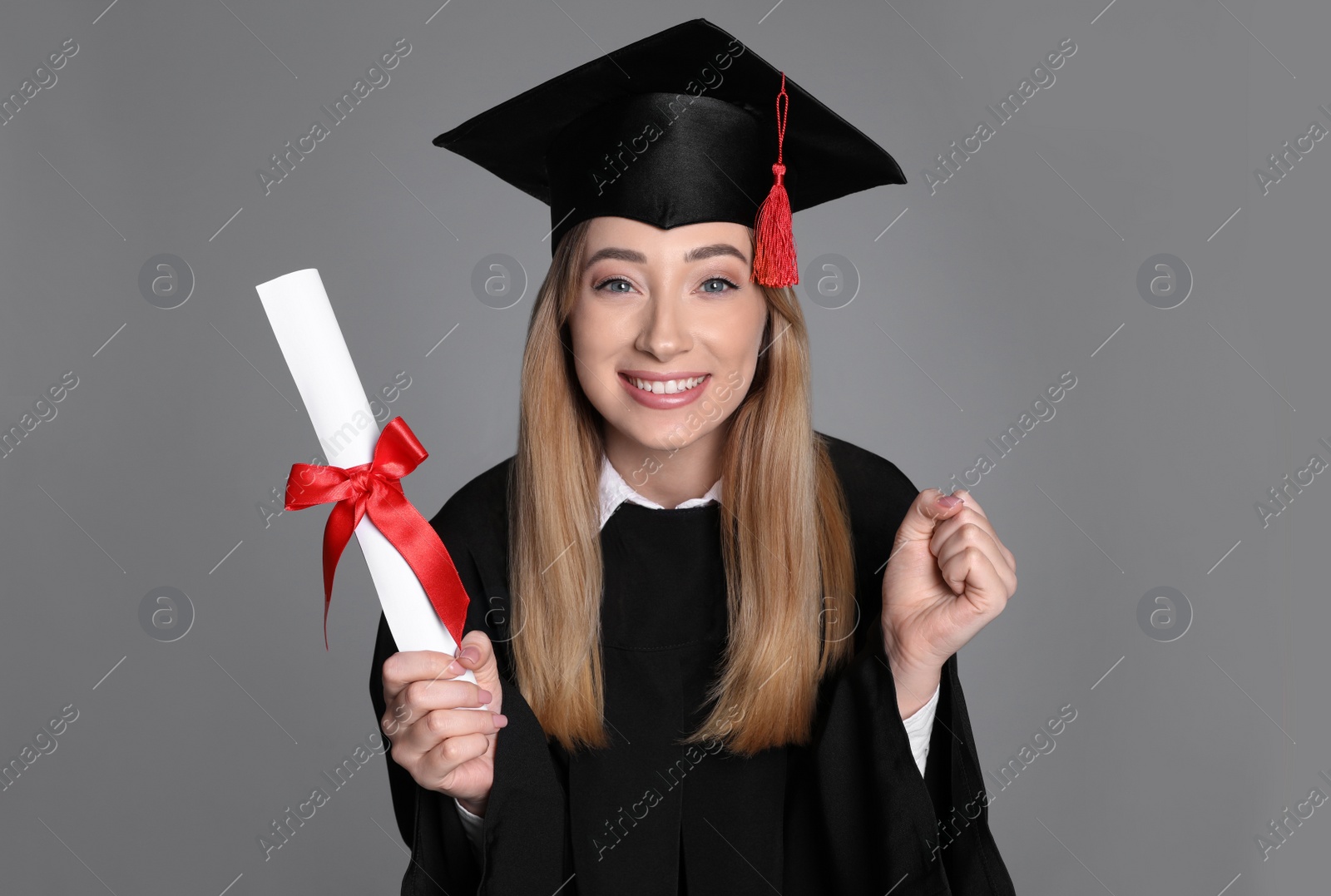 Photo of Happy student with diploma on grey background