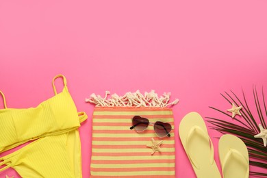 Flat lay composition with different beach objects on pink background, space for text