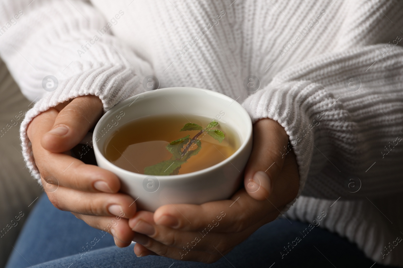 Photo of Woman drinking tasty herbal tea, closeup view