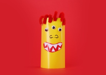 Funny yellow monster on red background. Halloween decoration