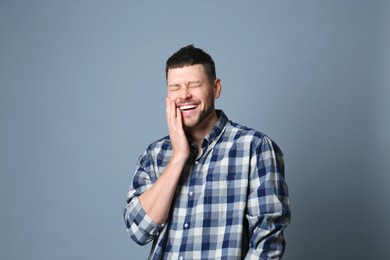 Photo of Handsome man laughing on grey background. Funny joke