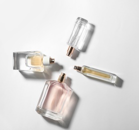 Photo of Bottles of perfume on light background, top view