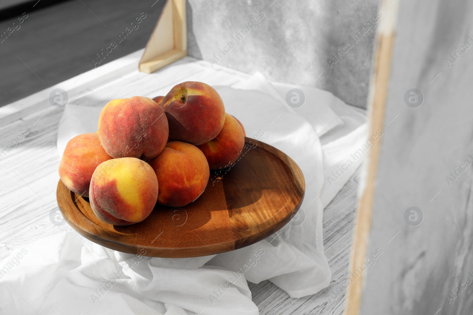 Photo of Stand with juicy peaches and double-sided backdrops in photo studio