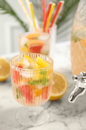 Photo of Delicious refreshing drink with orange and grapefruit on white marble table