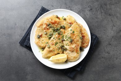 Photo of Delicious chicken piccata with herbs on grey table, top view