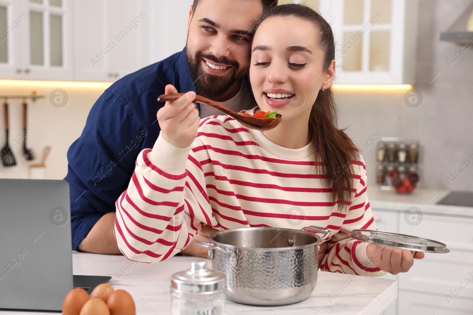 Photo of Happy lovely couple cooking together in kitchen