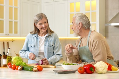 Photo of Happy senior couple cooking together in kitchen