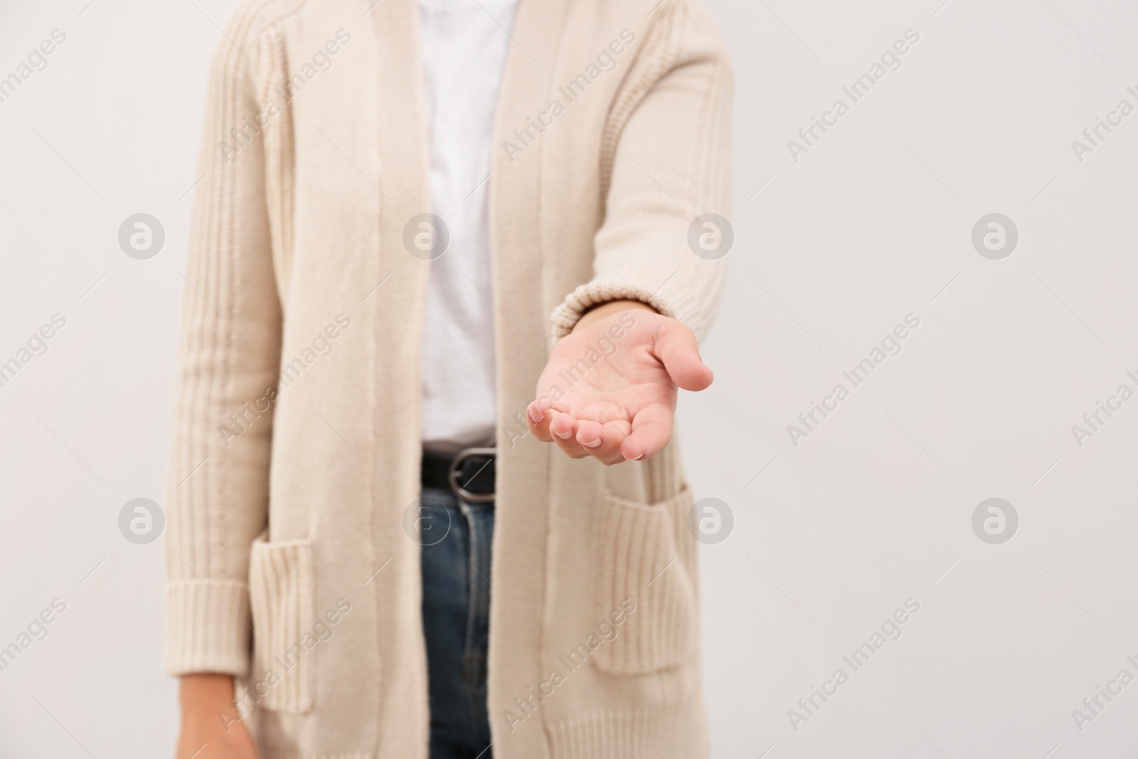 Photo of Woman giving helping hand on light background