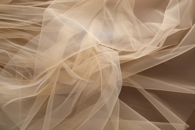 Photo of Beautiful tulle fabric on brown background, top view