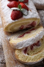 Pieces of delicious cake roll with strawberries and cream on table, above view