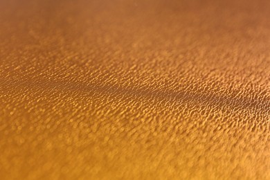 Photo of Golden textured surface as background, closeup view