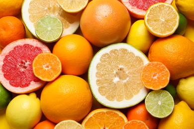 Photo of Different ripe citrus fruits as background, top view