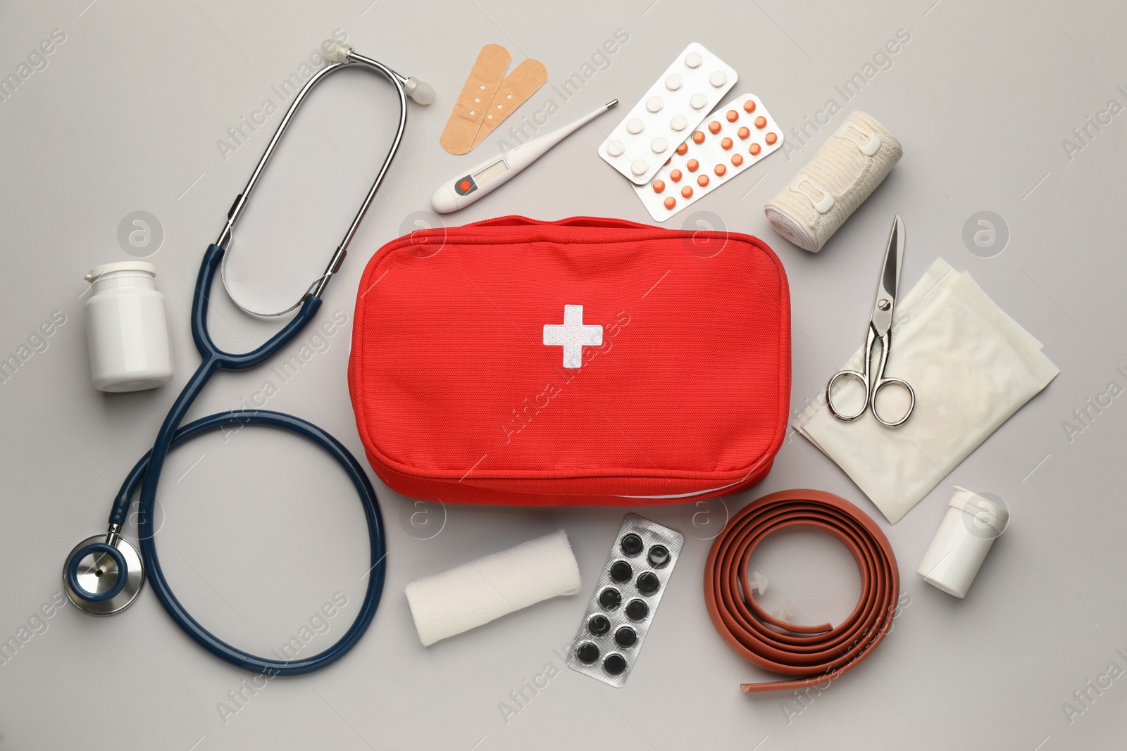 Photo of Flat lay composition with first aid kit on light grey background