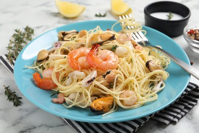 Photo of Delicious pasta with sea food served on white marble table, closeup
