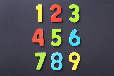 Photo of Colorful numbers on black background, flat lay