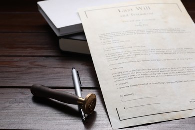 Photo of Last Will and Testament, stamp seal, books and pen on wooden table