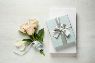Photo of Elegant gift boxes and beautiful flowers on white table, flat lay