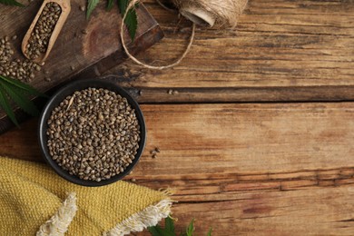 Flat lay composition with hemp seeds on wooden table. Space for text