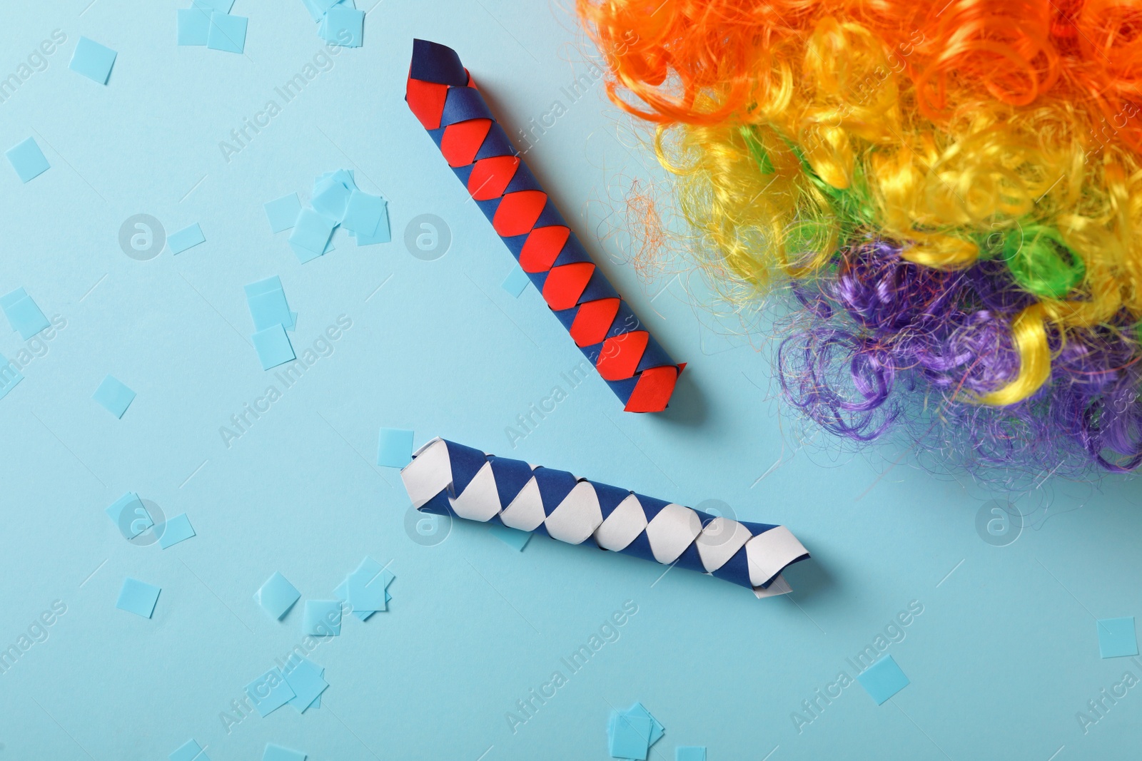 Photo of Different clown's accessories on light blue background, flat lay