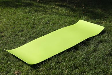 Bright exercise mat on fresh green grass outdoors