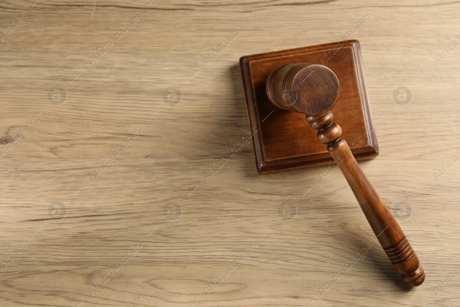 Photo of Wooden gavel and sound block on table, top view. Space for text