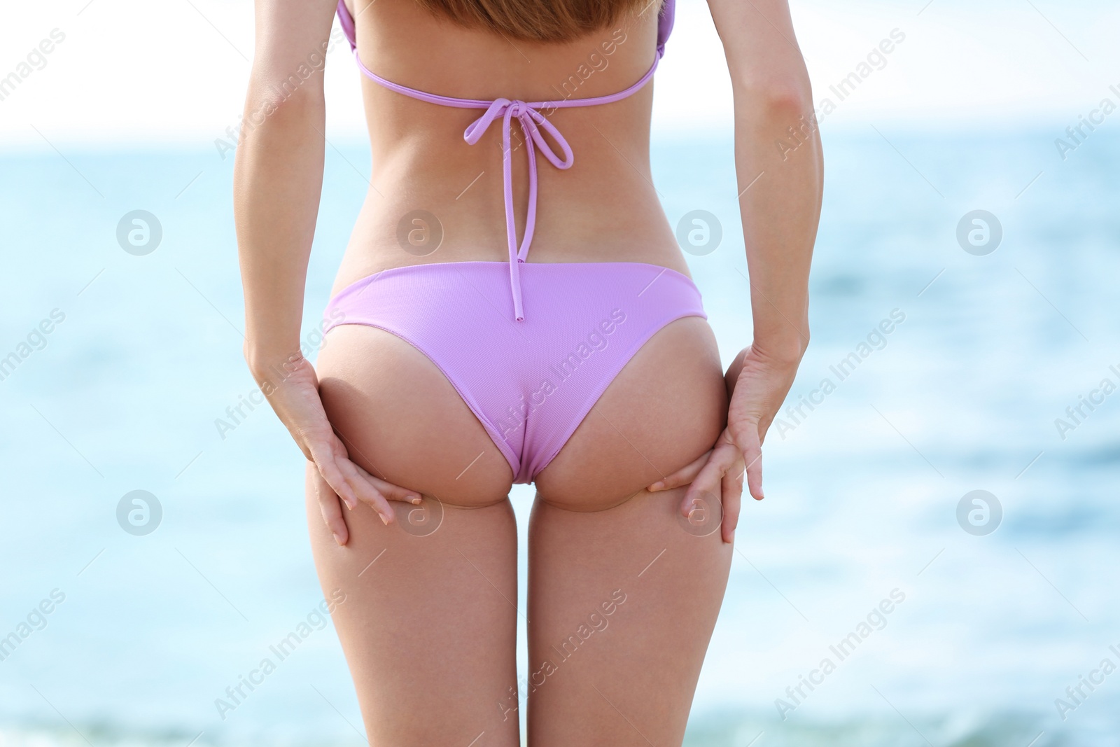 Photo of Attractive young woman in beautiful bikini swimsuit on beach, closeup