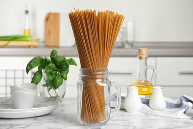 Uncooked buckwheat noodles on white marble table in kitchen