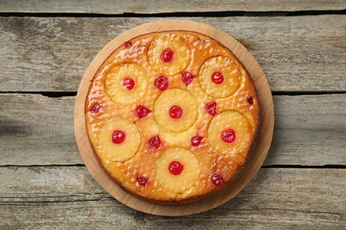 Tasty pineapple cake with cherries on wooden table, top view