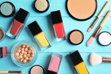 Flat lay composition with bottles of nail polish and different cosmetics on color background