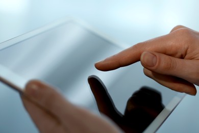 Photo of Closeup view of woman using modern tablet on blurred background