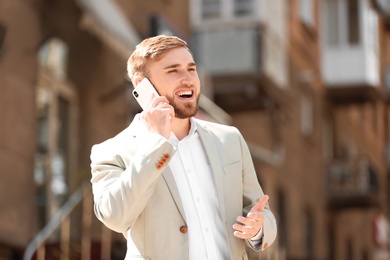 Portrait of young businessman talking on phone outdoors