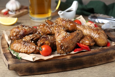 Photo of Tasty chicken glazed in soy sauce served on wooden table, closeup