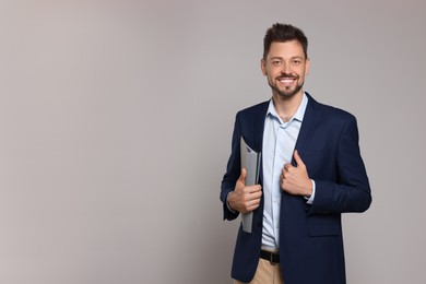 Photo of Happy teacher with stationery against beige background. Space for text