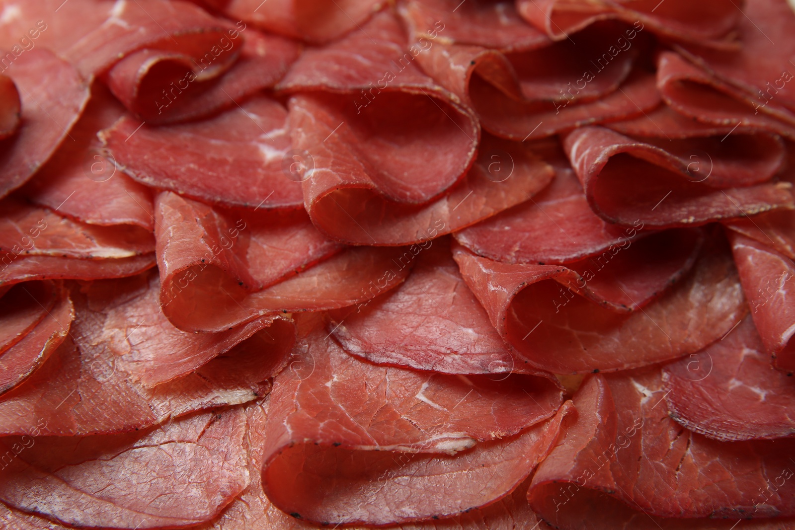 Photo of Slices of tasty bresaola as background, closeup