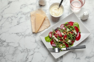 Plate with delicious beet salad on table, top view