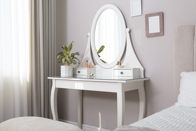 Photo of Elegant dressing table with mirror near window in bedroom