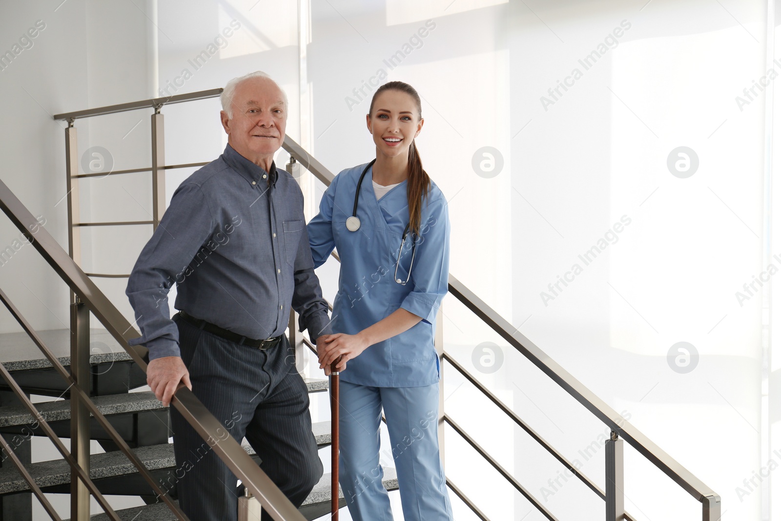 Photo of Doctor helping senior patient in modern hospital