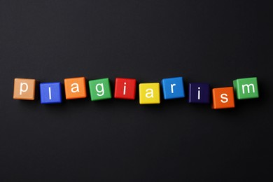 Photo of Colorful cubes with word Plagiarism on black background, flat lay