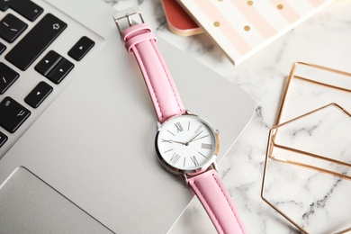 Stylish wrist watch and laptop on office table. Time management