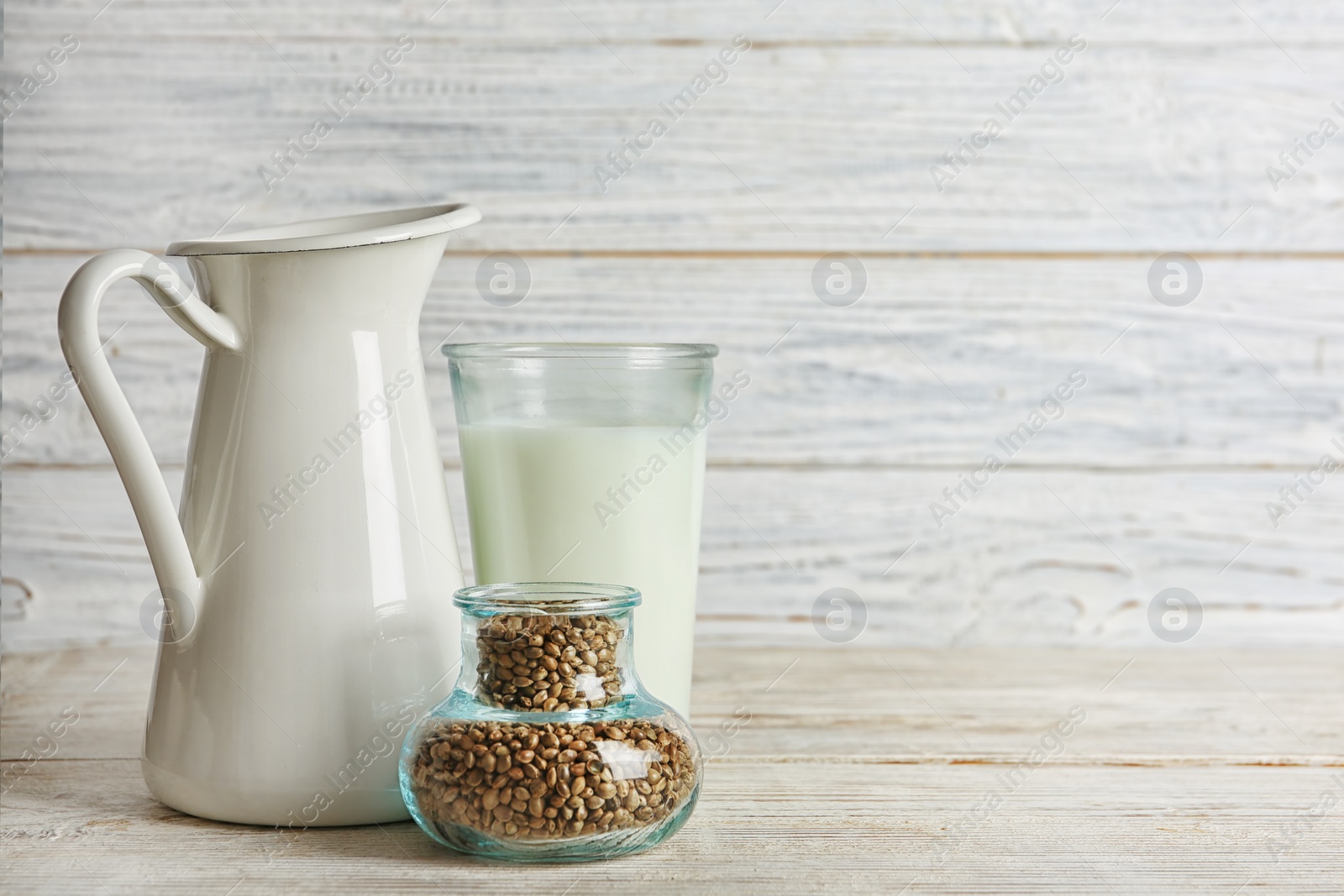 Photo of Composition with hemp seeds, milk and space for text on wooden background