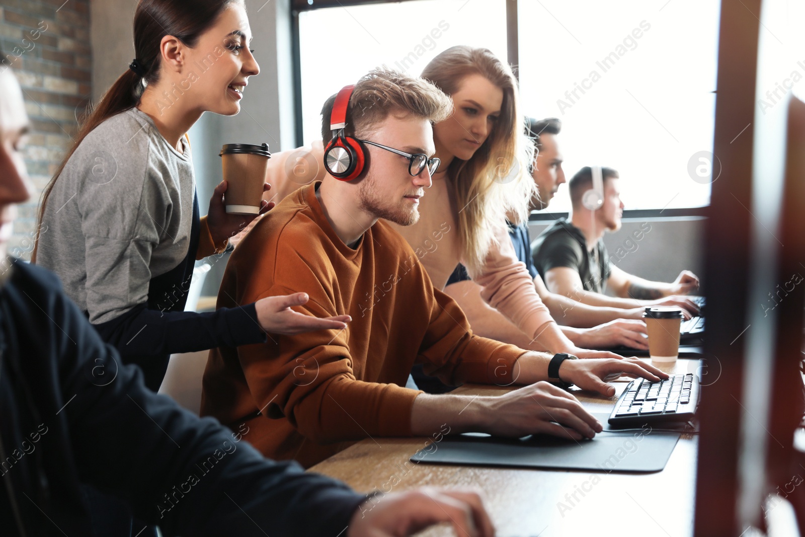 Photo of Group of people playing video games in internet cafe