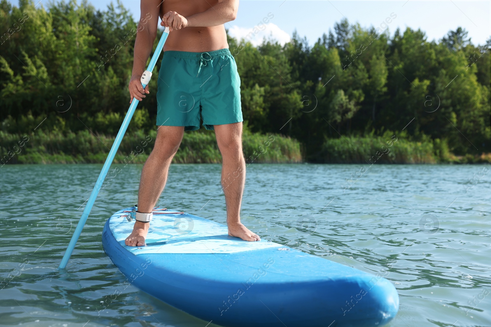 Photo of Man paddle boarding on SUP board in river, closeup