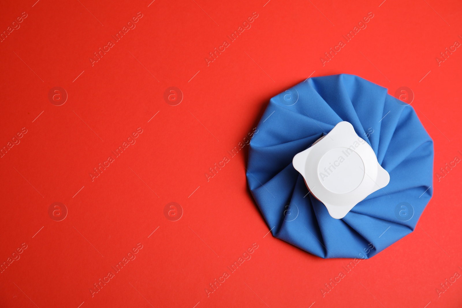 Photo of Ice pack on red background, top view. Space for text