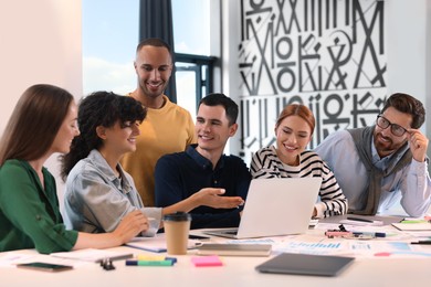 Photo of Team of employees working together at table in office. Startup project